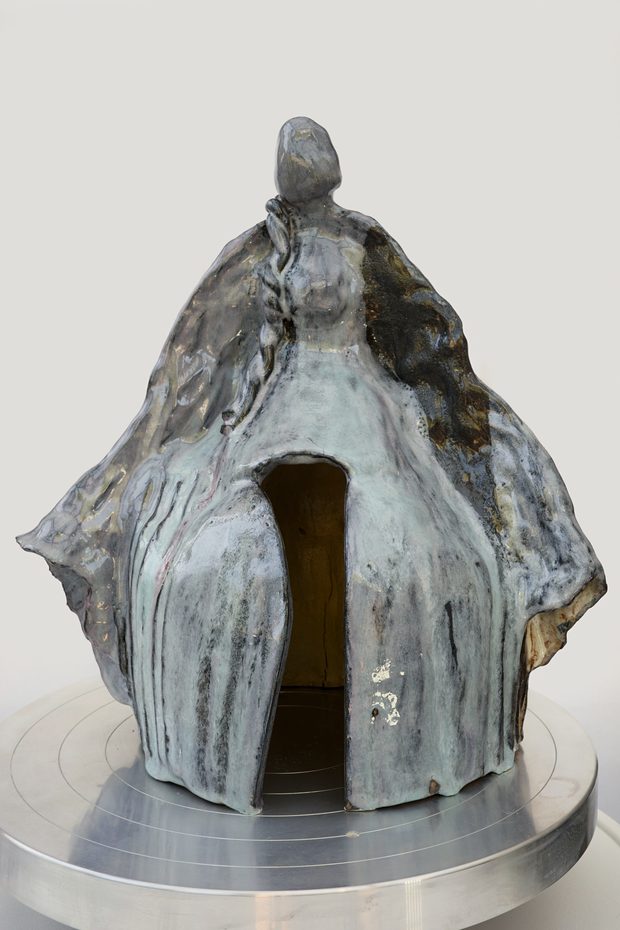 Sanctuary — cloaked standing figure opening into a sheltered doorway, smoky blue-grey glaze.