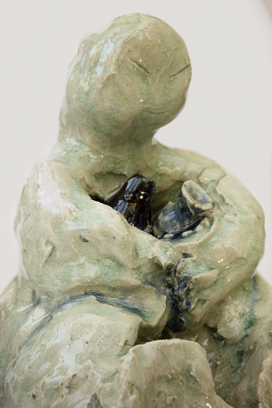The Pot Keeper — seated figure with lowered face, cradling a dark cobalt form.