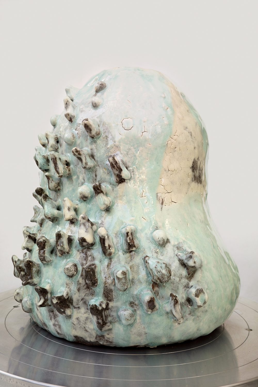 Carrying The Mountains — hand-built stoneware sculpture with a barnacled surface in a pale celadon glaze.