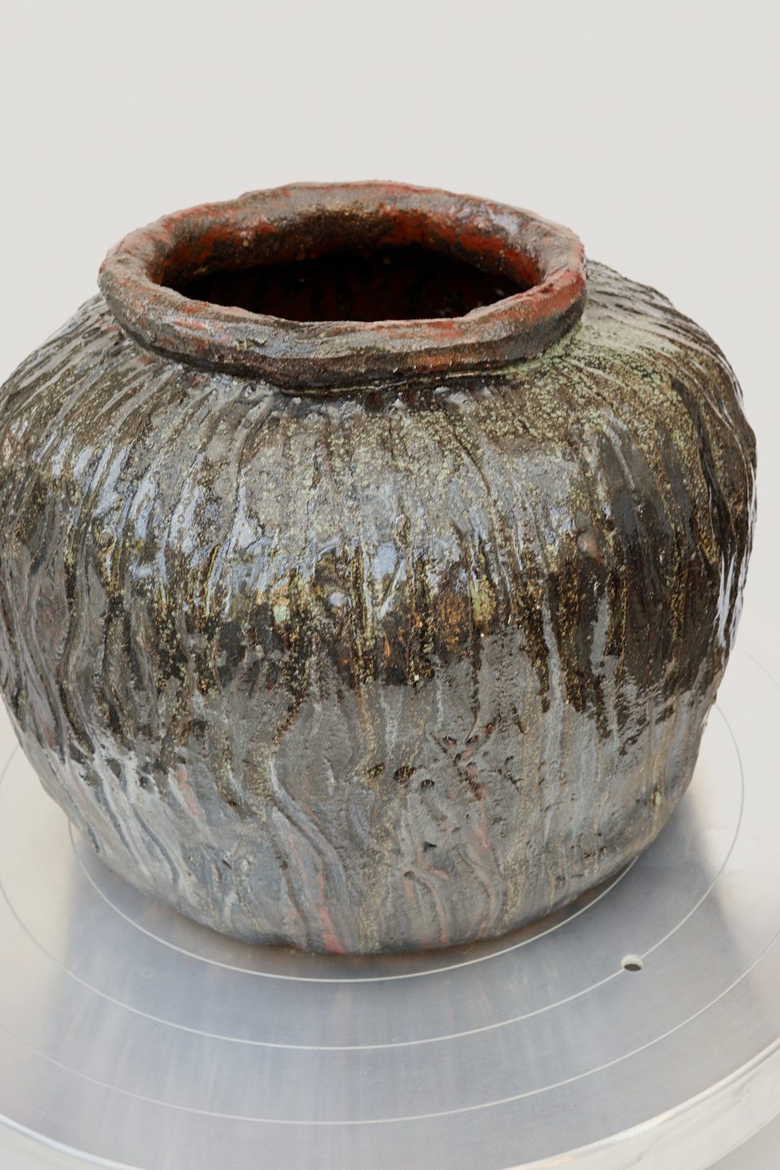 Vessel 2 — ribbed stoneware jar with an iron-red rim.