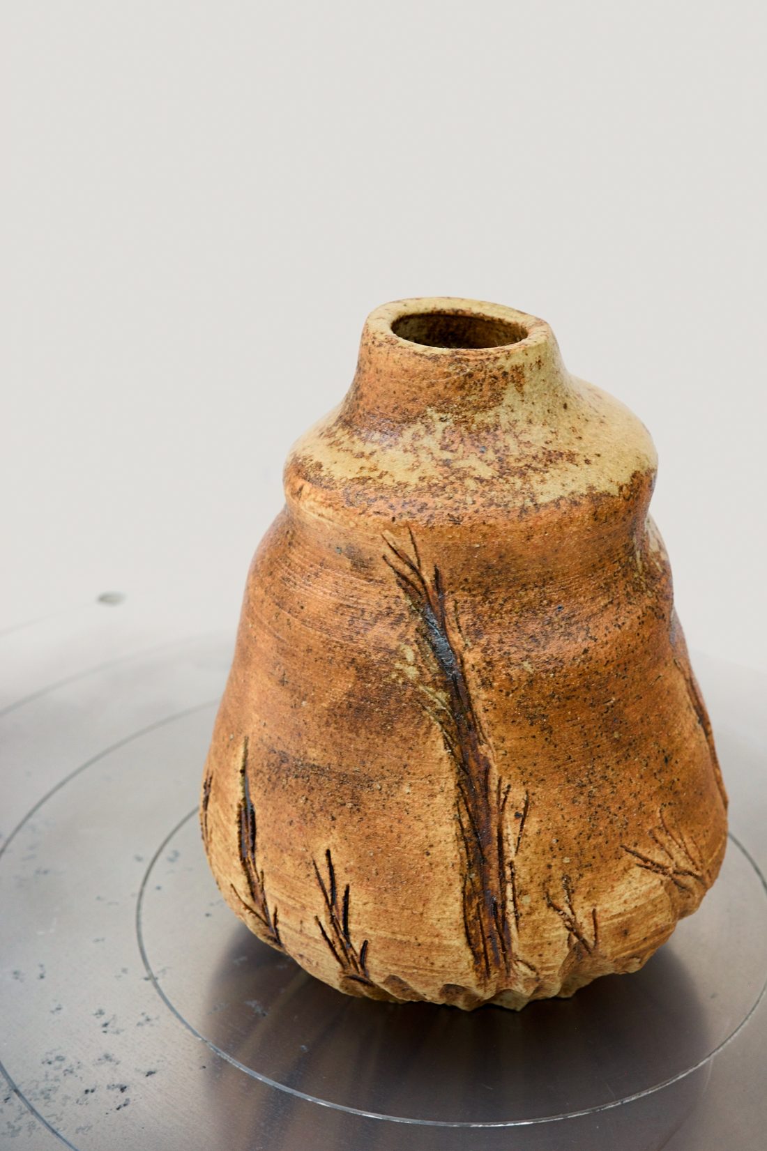Ember Wheat — terracotta sake bottle with form with vertical fissures and a soft matt surface.