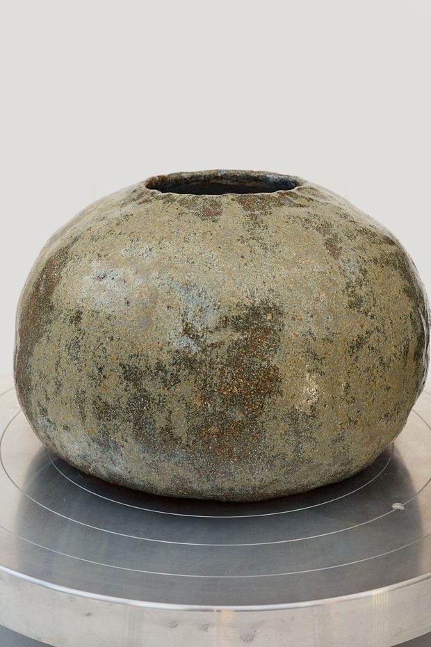 Vessel 1 — rounded spherical vessel with a narrow opening and a dry olive surface.