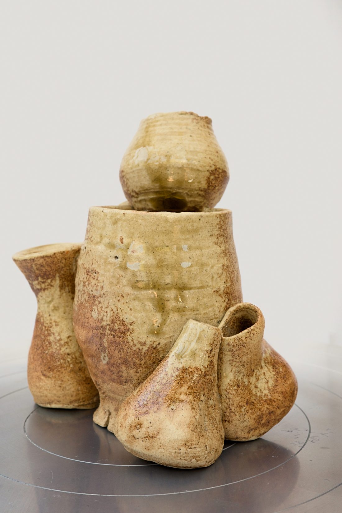 The Pots Gatherer — a cluster of small ochre vessels grouped together.